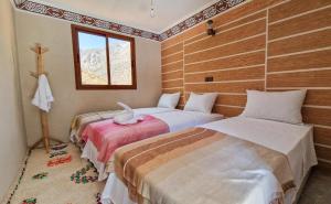 伊姆利尔Toubkal Views的一间卧室设有两张床和窗户。