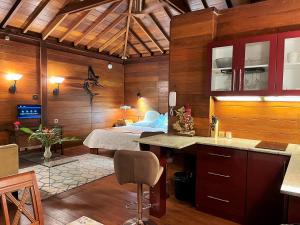 马埃岛Bois Joli的卧室配有一张床铺,位于带木墙的房间内