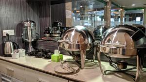 丹戎槟榔Kita Hotel的厨房在柜台上设有三个大银碗