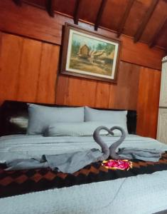 普拉亚Bujak Permai Villa Matahari Lombok NTB的一张有两只天鹅的睡床,上面有一颗心