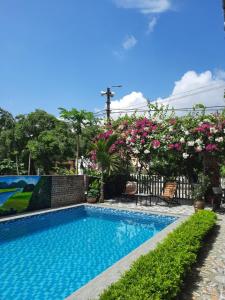 宁平Tam Coc Viet Ha Homestay的围栏上种有粉红色花的游泳池