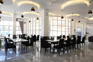 ApalengJ&V Hotel and Resort的用餐室设有桌椅和窗户。
