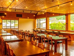 由布市雅瓦拉其佐藤雅多亚酒店的餐厅设有木桌、椅子和窗户。