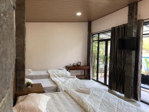 布罗莫布罗莫营地之家的一间卧室设有三张床,墙上设有一台电视机
