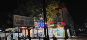 贾巴尔普尔SPOT ON 81358 Sun Shine Hotel的一群商店在晚上在城市街道上