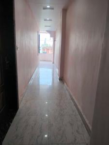 MadhubaniOYO 81285 Hotel Chanda的空的走廊,有粉红色墙壁的房间