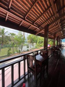 琅勃拉邦Golden Lotus Namkhan River View的餐厅设有桌椅和大窗户。