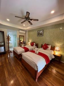 琅勃拉邦Golden Lotus Namkhan River View的一间卧室配有两张床和吊扇