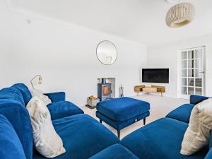 波特里斯Fairwinds的客厅配有蓝色的沙发和电视