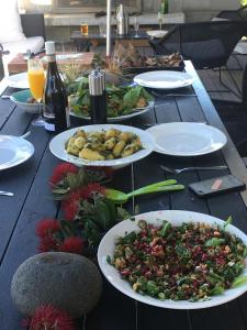 大堡礁岛Medlands Beach House的一张木桌,上面放着食物和葡萄酒