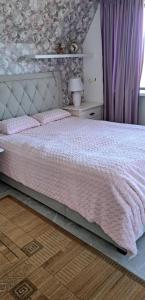 Viimsiroom to the east的一间卧室配有一张带粉红色棉被的床