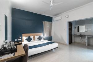 KhandagiriNamaskar Silverkey的一间酒店客房,一间设有一张床和一张书桌