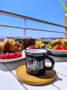 索林Luxury apartment Salona的咖啡杯坐在木板上,上面有一盘食物