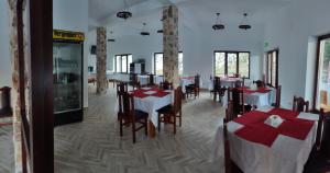 阿列谢尼Pensiunea Trei Brazi Arieseni的餐厅内带桌椅的用餐室