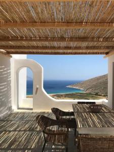 伊奥斯乔拉Cyclades, villa surplombant la mer的海景甲板配有桌椅