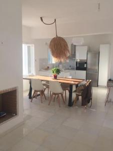 伊奥斯乔拉Cyclades, villa surplombant la mer的一间带木桌和椅子的厨房以及一间用餐室