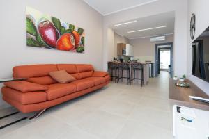 卡塔尼亚iitana Luxury Apartment - Catania Fronte Mare的一间带橙色沙发的客厅和一间厨房