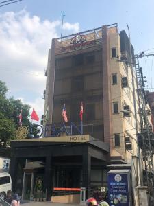 拉合尔Hotel Oban的酒店大楼的顶部有旗帜