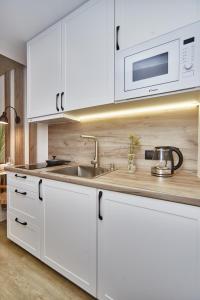 敖德萨City Rooms Arcadia Self Check-In的白色的厨房配有水槽和微波炉