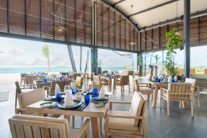 美慕环礁Madifushi Private Island的一间设有桌椅的海洋餐厅