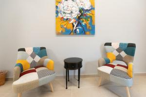 卡塔尼亚iitana Luxury Apartment - Catania Fronte Mare的画室里配有两把椅子和一张桌子