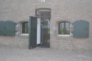Nieuwendijk巴克思奇堡住宿加早餐旅馆的砖砌建筑的开放式门,设有两扇窗户