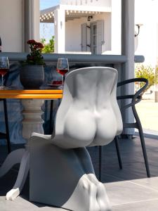 布拉卡Sea Lilies Suites的一张带酒杯的桌子旁的白色椅子