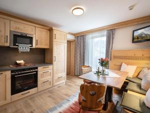 格英斯哈纳普尔霍夫酒店的厨房配有木制橱柜、桌子和沙发。