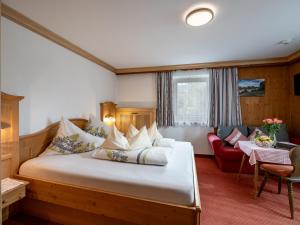 格英斯哈纳普尔霍夫酒店的一间卧室配有一张大床和一张红色的沙发