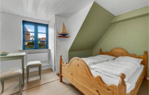 阿灵厄Amazing Apartment In Allinge With Wifi And 3 Bedrooms的一间卧室配有一张床、一张书桌和一个窗户。