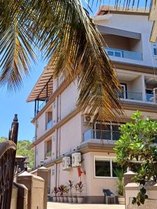 莫尔吉姆Ariena by Spree Hotels Goa的前面有棕榈树的建筑