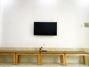 头顿Prana Vũng Tàu的挂在白色墙壁上的平面电视