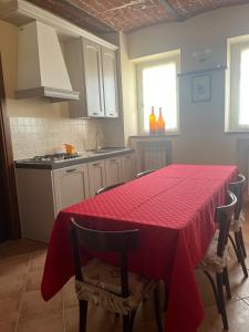 Rosignano MonferratoCa' dal Bertu - Cascina in Monferrato的厨房配有一张桌子,上面有红色的桌布