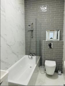 伦敦Gorgeous split level Belsize Park Apartment的浴室配有白色浴缸和卫生间。