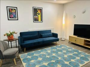 伦敦Gorgeous split level Belsize Park Apartment的客厅配有蓝色的沙发和电视