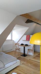 汉堡steenkampstudios LOFT的阁楼上的卧室配有床和桌子