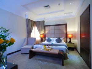 科威特科威特法哈希尔波德酒店的配有一张床和一把椅子的酒店客房