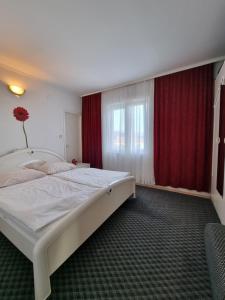 拉布Apartman Zlatko, Palit, Rab的卧室配有白色大床和红色窗帘