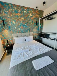 凯麦尔Euronova Hotels & Suites的一间卧室设有一张大床和色彩缤纷的墙壁