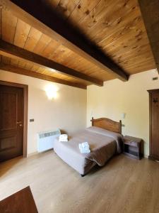 PreturoLocanda San Pietro的一间卧室设有一张大床和木制天花板