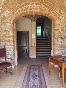 PreturoLocanda San Pietro的走廊上设有石拱门、桌子和楼梯