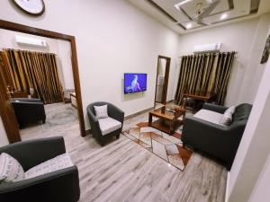 拉合尔Hayyat Luxury Apartments的带沙发、椅子和镜子的客厅