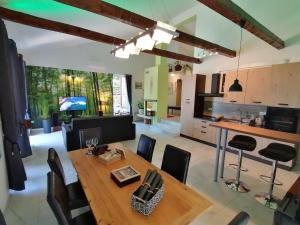 克拉斯The Forest House Krk 2的厨房以及带木桌和椅子的客厅。