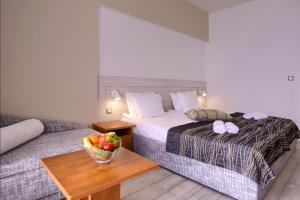 金沙Luna Beach Hotel - Half Board & All Inclusive的酒店客房,配有一张床和一碗水果放在桌子上