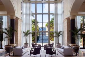 迈阿密迈阿​​密力丽思卡尔顿椰林酒店 的大堂设有白色家具和大窗户。