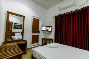 贾夫纳Pearl Island Inn的客房设有两张床、镜子和电视。