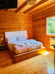 RubikBujtina Dini的小木屋内一间卧室,配有一张床