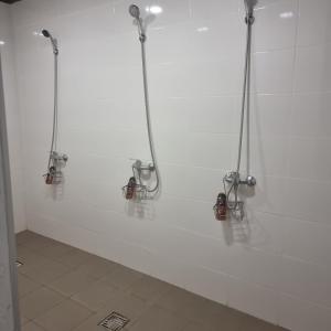 尤尔巴尔卡斯Camp Genys的白色墙壁上的浴室设有3个淋浴系统