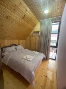 BangvetiKirta的木制客房的一张床铺,设有大窗户