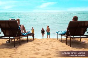 科伦坡科伦坡马里诺海滩酒店的一群人坐在沙滩上的椅子上